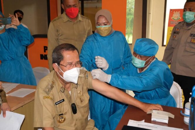 
					Wakil Bupati Parigi Moutong, H. Badrun Nggai, SE menjadi orang yang pertama mendapatkan suntikan vaksinasi, saat kegiatan Vaksinasi Covid- 19 Dosis lanjutan (Booster) di kantor Bupati, Senin 21 Februari 2022. | Foto : Humas