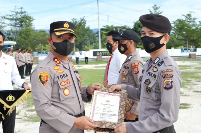 
 Kapolres Banggai, Sulawesi Tengah, AKBP Yoga Priyahutama, memberikan penghargaan kepada salah satu personil Polisi pada apel gabungan di halaman Mako Polres Banggai, Senin 14 Februari 2022. (Foto : Humas Polres Banggai)